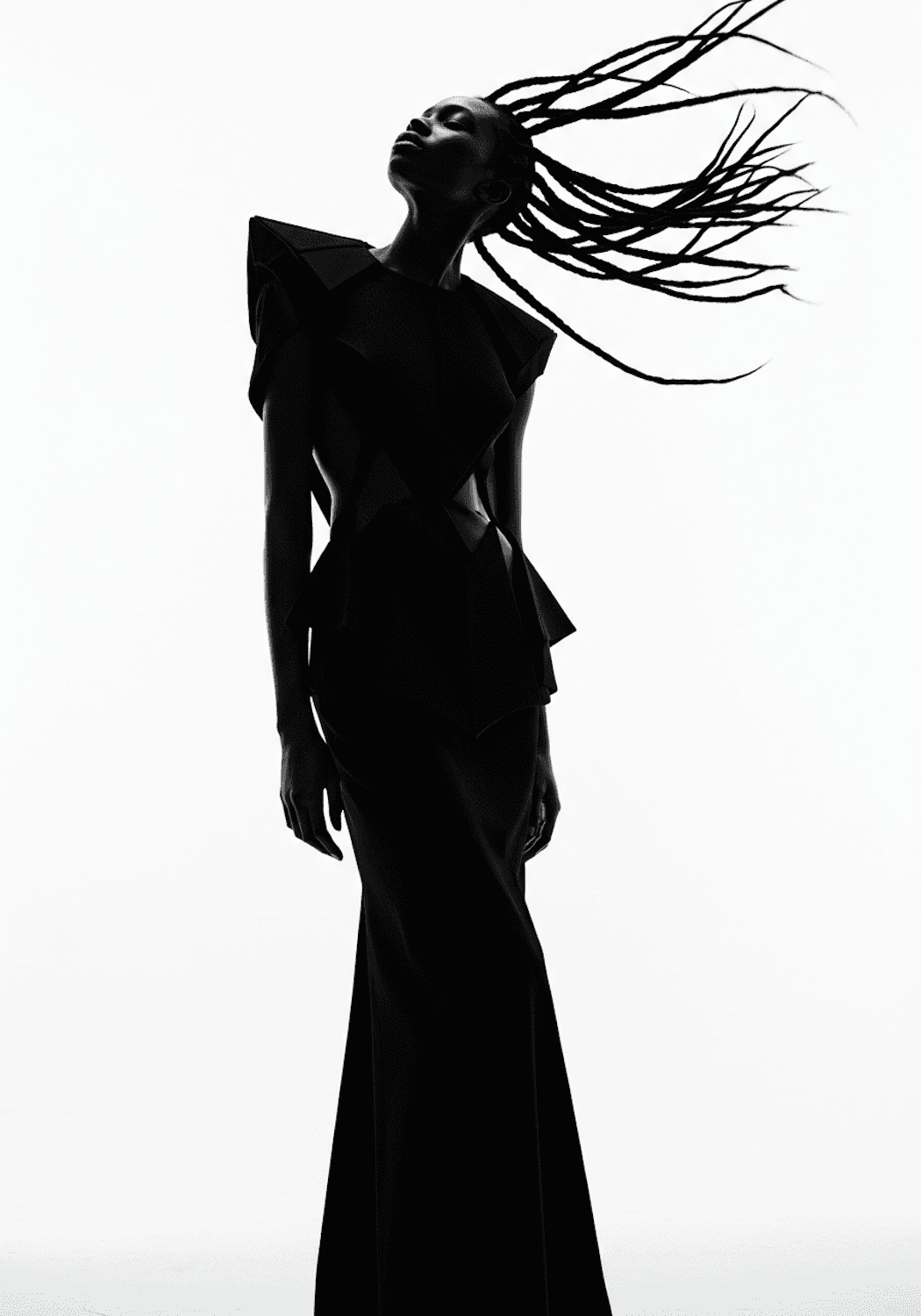 Model in a sculptural black gown photographed in silhouette against the light, her braids caught in motion