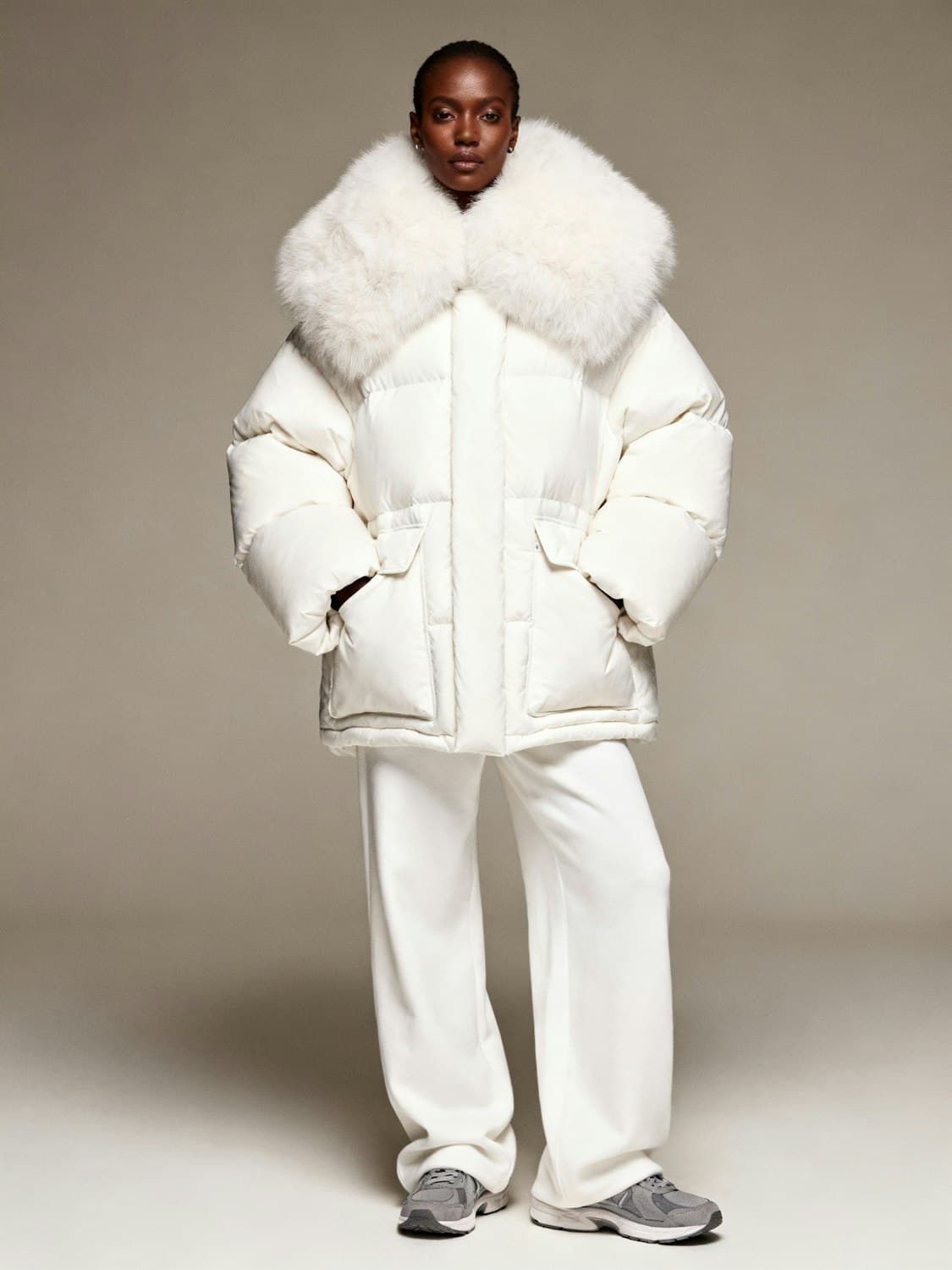 Model in an ivory quilted down coat with an oversized shearling collar