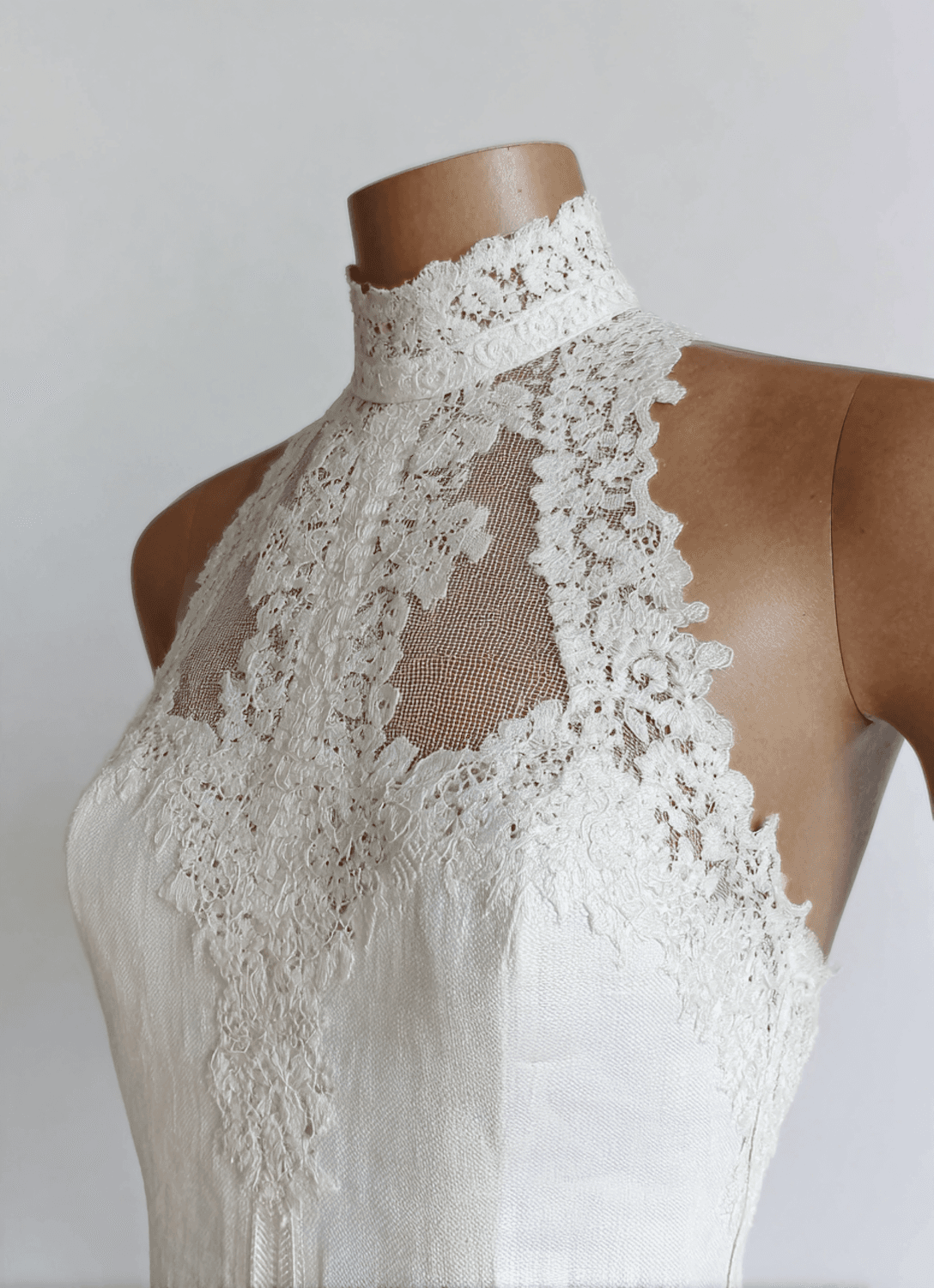 Ivory lace bodice with a high collar on a dressmaker form