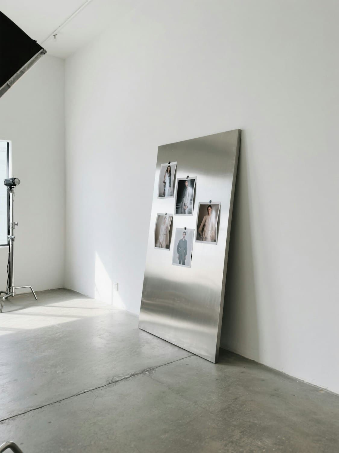 The design studio of the Maison, with collection photographs pinned to a steel board in morning light